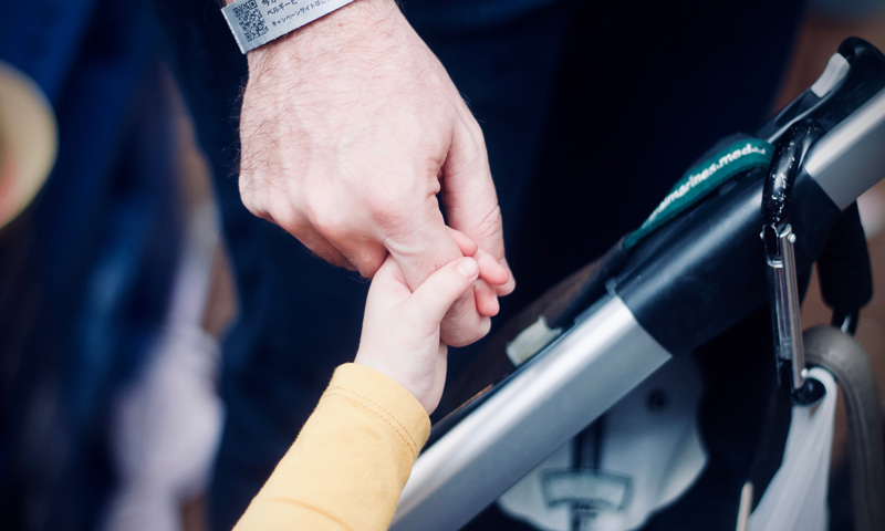 father holds his child’s hand