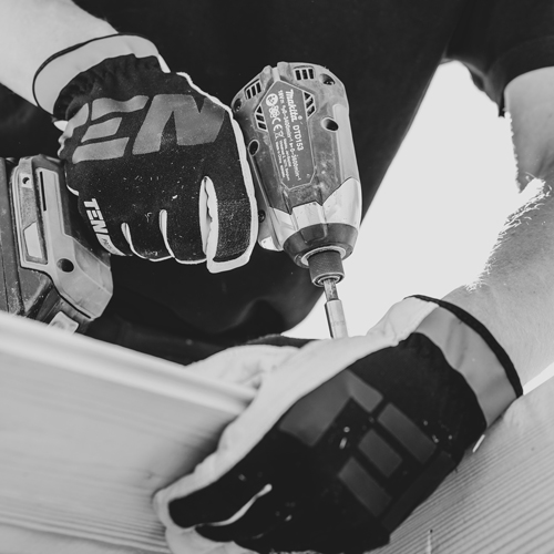 carpenter with work gloves roofs a building