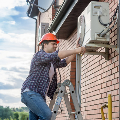 man repairing a condenser unit