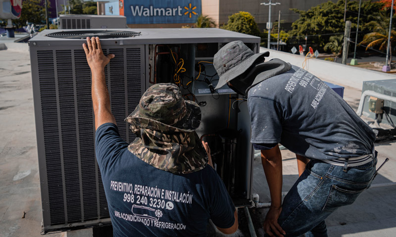 technicians inspecting a commercial HVAC unit’s interior